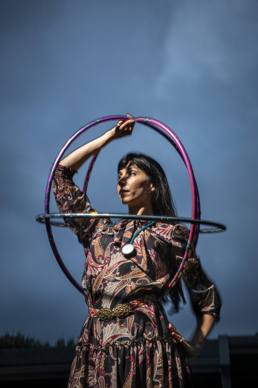 With a stethoscope around her neck, G. Sofia Nelson holds hula hoops used in her dance pieces.