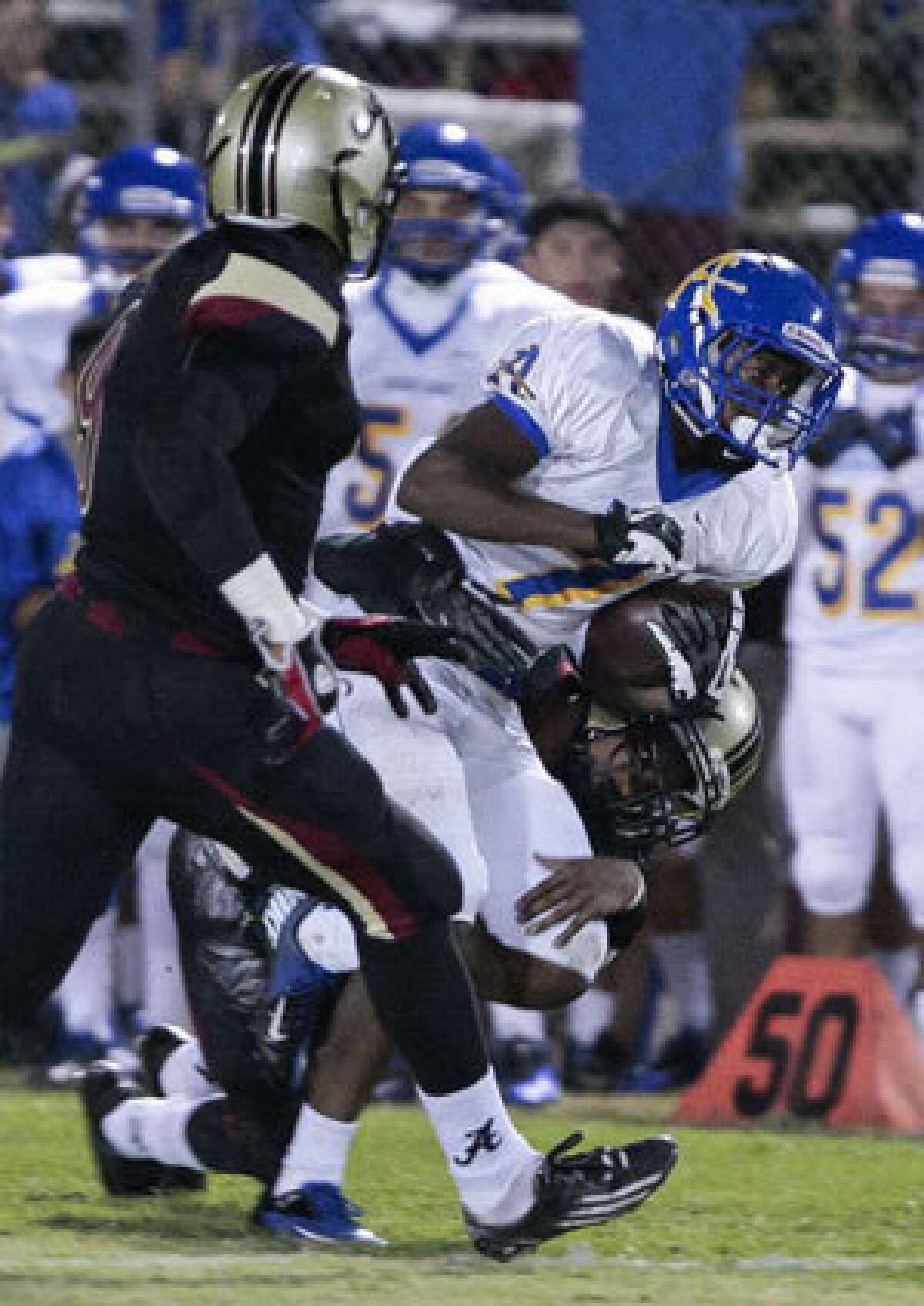 Bishop Amat wide receiver Darren Andrews is dragged down after making a catch against Alemany on Oct. 12.