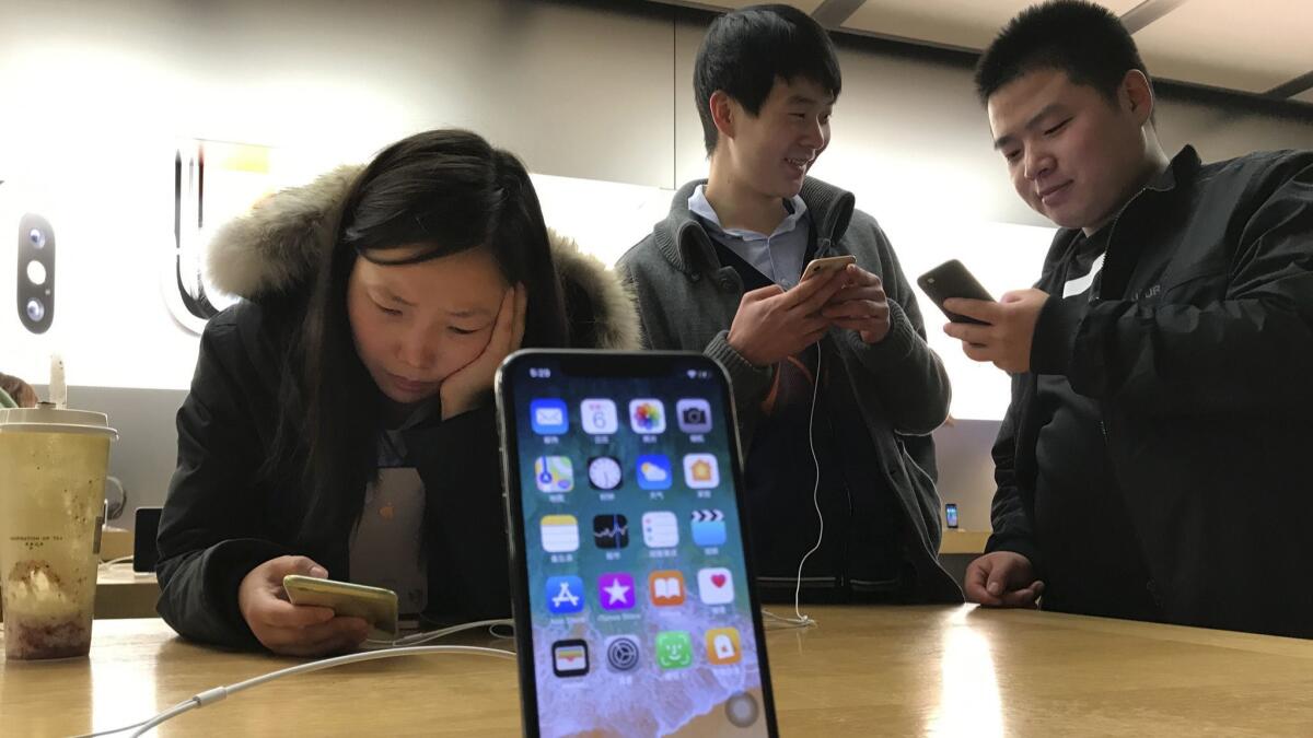 Shoppers check out the iPhone X at an Apple store in Beijing in 2017.