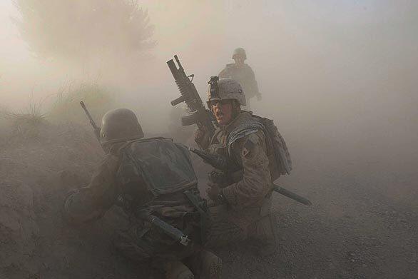 A U.S. Marine with the 2nd Marine Expeditionary Brigade, RCT 2nd Battalion 8th Marines Echo Co. along with an Afghan soldier react as dust blankets the area after an IED exploded while they were under enemy fire on July 17, 2009 in Mian Poshteh, Afghanistan. The Marines are part of Operation Khanjari which was launched to take areas in the Southern Helmand Province that Taliban fighters are using as a resupply route and to help the local Afghan population prepare for the upcoming presidential elections.