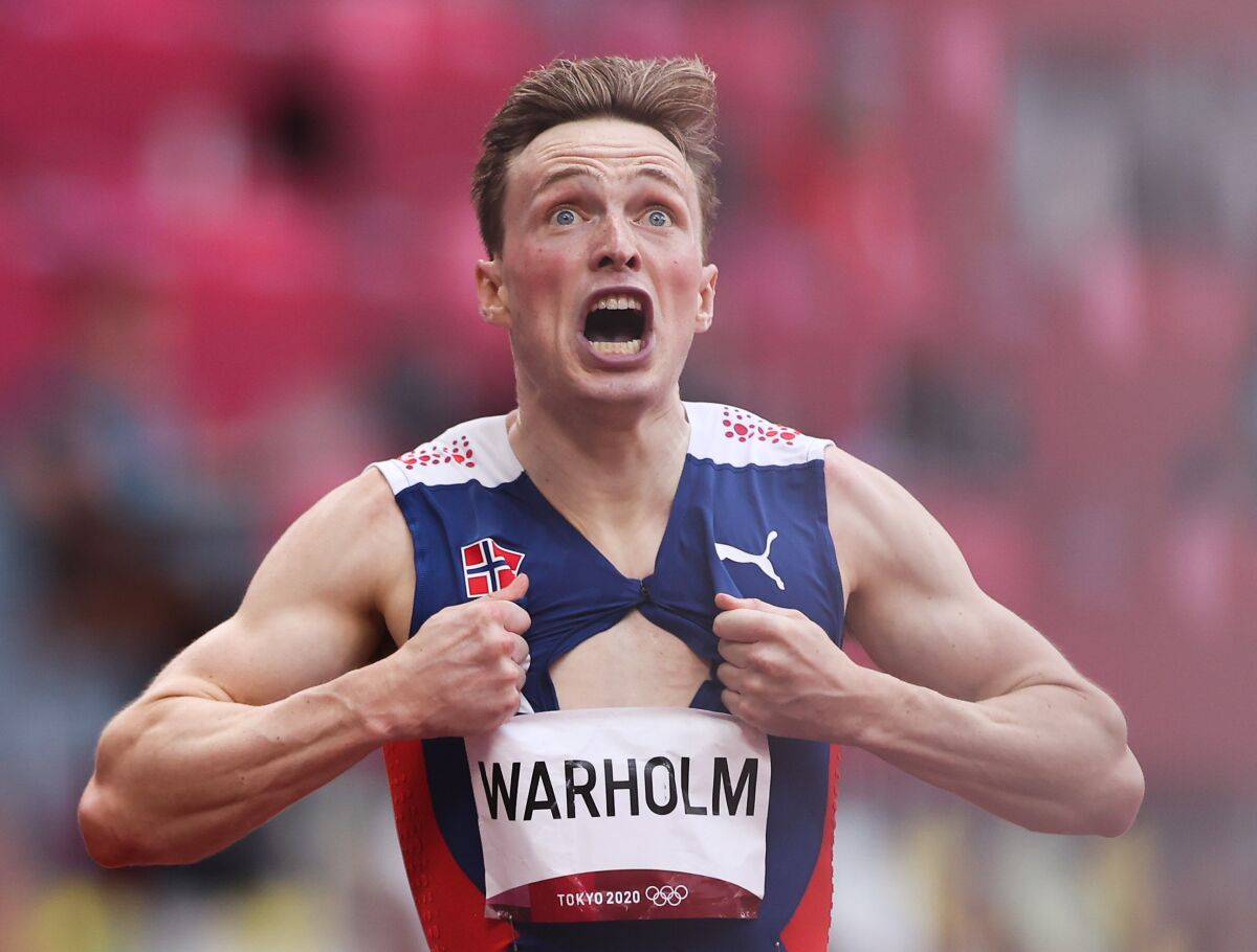 Karsten Warholm of Team Norway tears open his running singlet