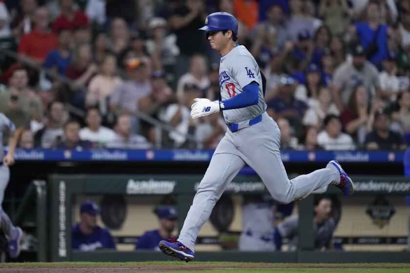 Los Angeles Dodgers designated hitter Shohei Ohtani scores on a sacrifice fly hit by Jason Heyward during the ninth inning of a baseball game against the Houston Astros, Sunday, July 28, 2024, in Houston. (AP Photo/Kevin M. Cox)