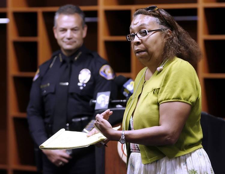 With Pasadena Police Chief Phillip Sanchez, looking on in the background, local businesswoman Debera Penman talks about living in a Pasadena community where people respect each other, during informational meeting about recent racist graffiti in Northwest Pasadena, at the Rose Bowl in Pasadena on Saturday, August 20, 2011.