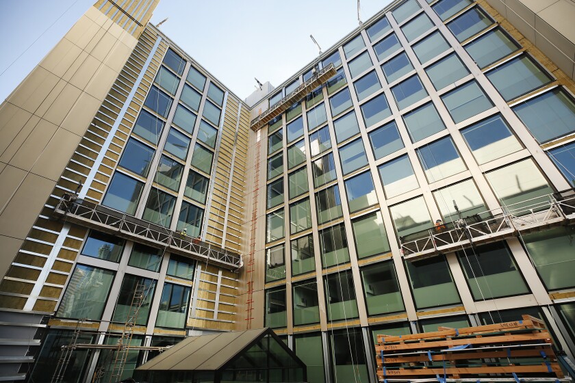 Workmen complete finishing details to the exterior of the CitizenM hotel