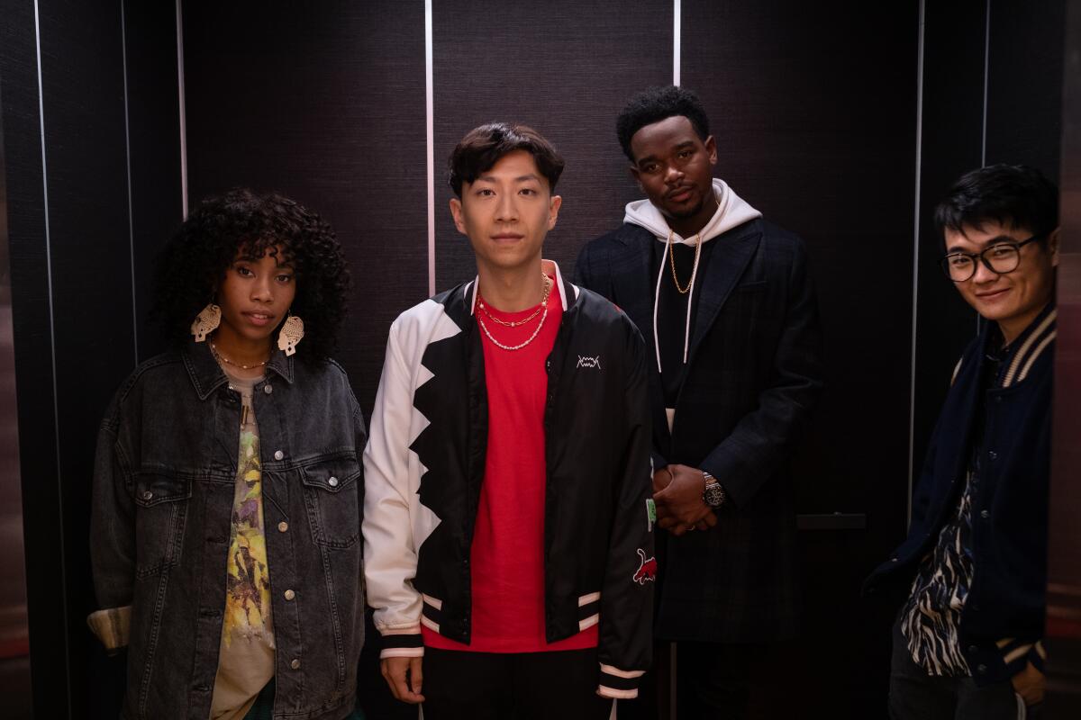 Four young actors standing side by side in an elevator.