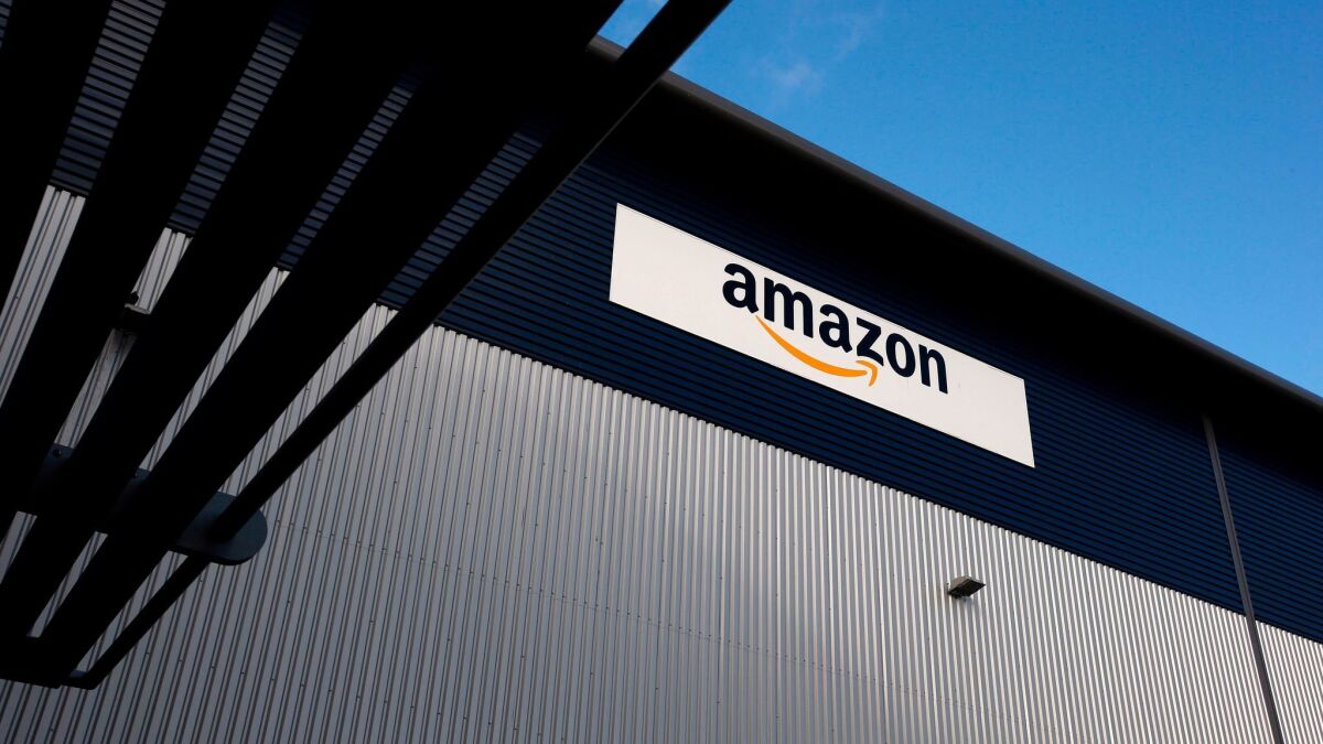 An Amazon logo hangs on a wall outside a company fulfillment center near London on Nov. 25, 2015.