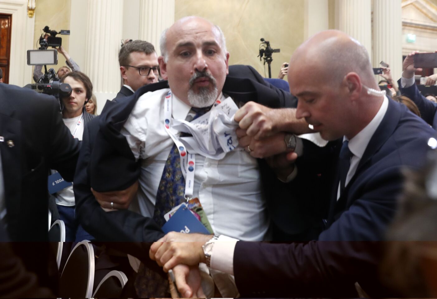 Security staff detain a man prior to a press conference by President Trump and Russian President Vladimir Putin at the Presidential Palace in Helsinki, Finland.