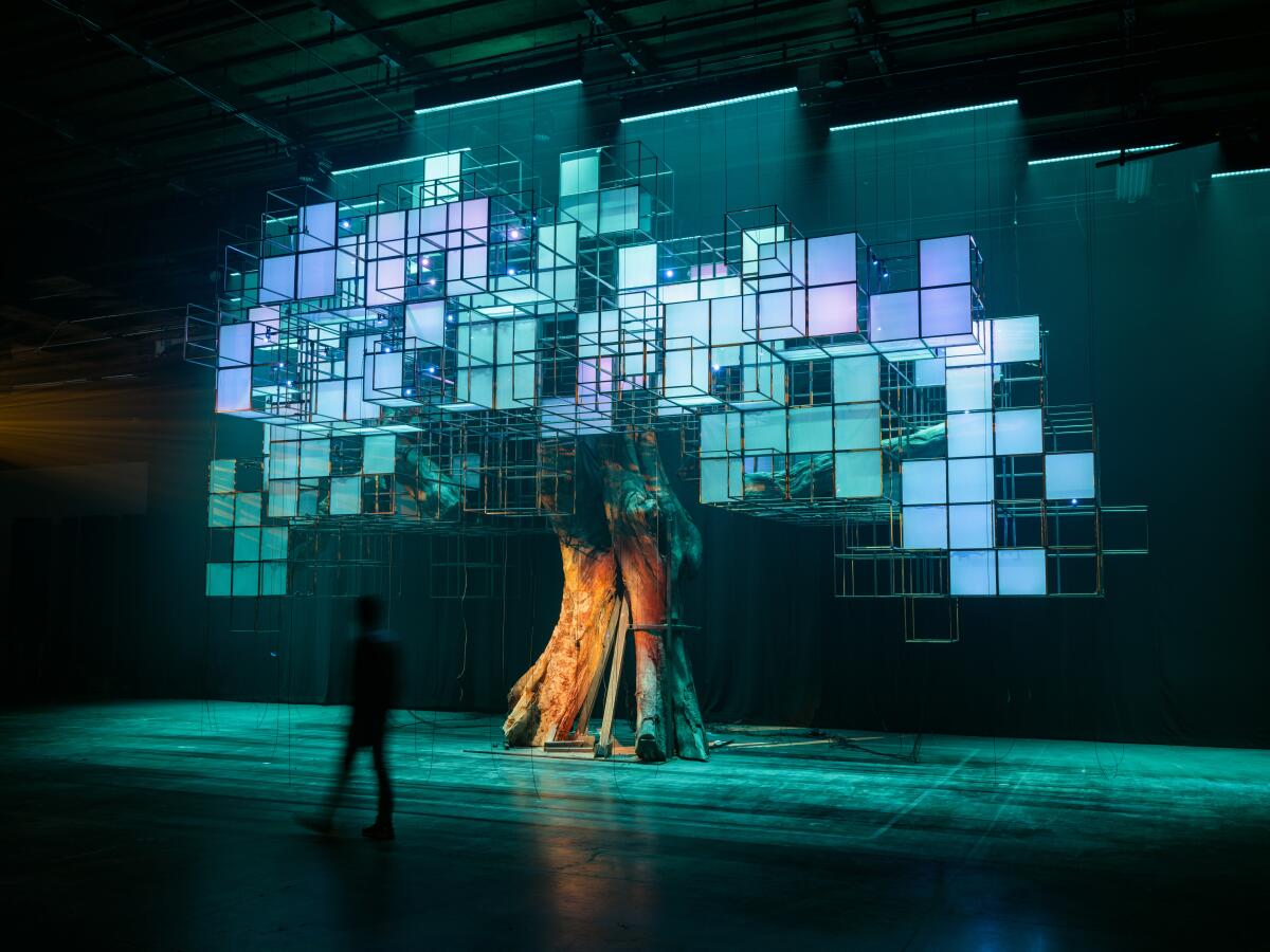 a tree with foliage made from glowing squares on a large wire frame