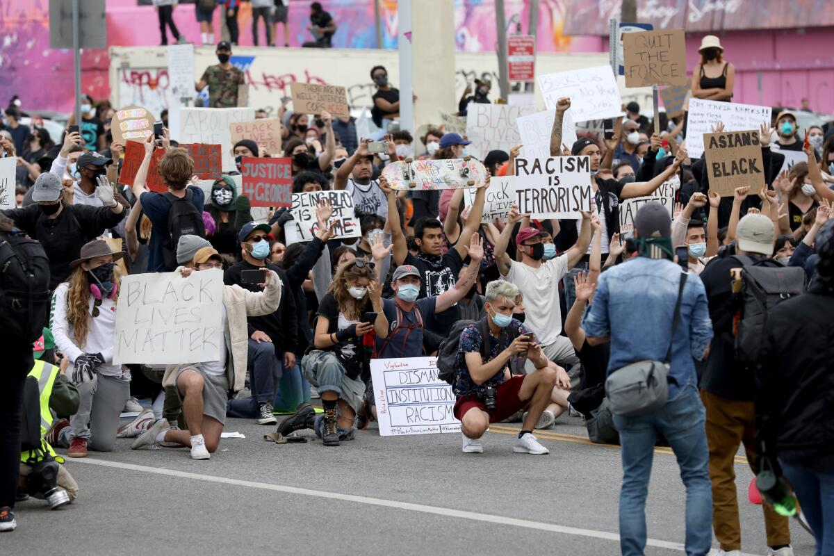 Protesters supporting Black Lives Matter kneel in an L.A. street on May 30.