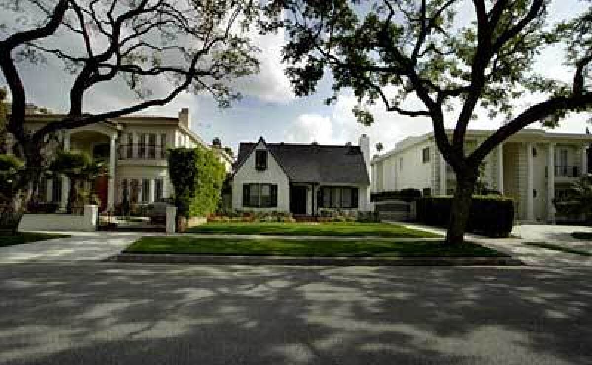 A Beverly Hills original sits between two larger buildings. The city was developed in 1906 by investors who had struck out on a quest for oil. Trees line the streets, and are maintained by the Urban Forestry Division under a 1996 street tree master plan.