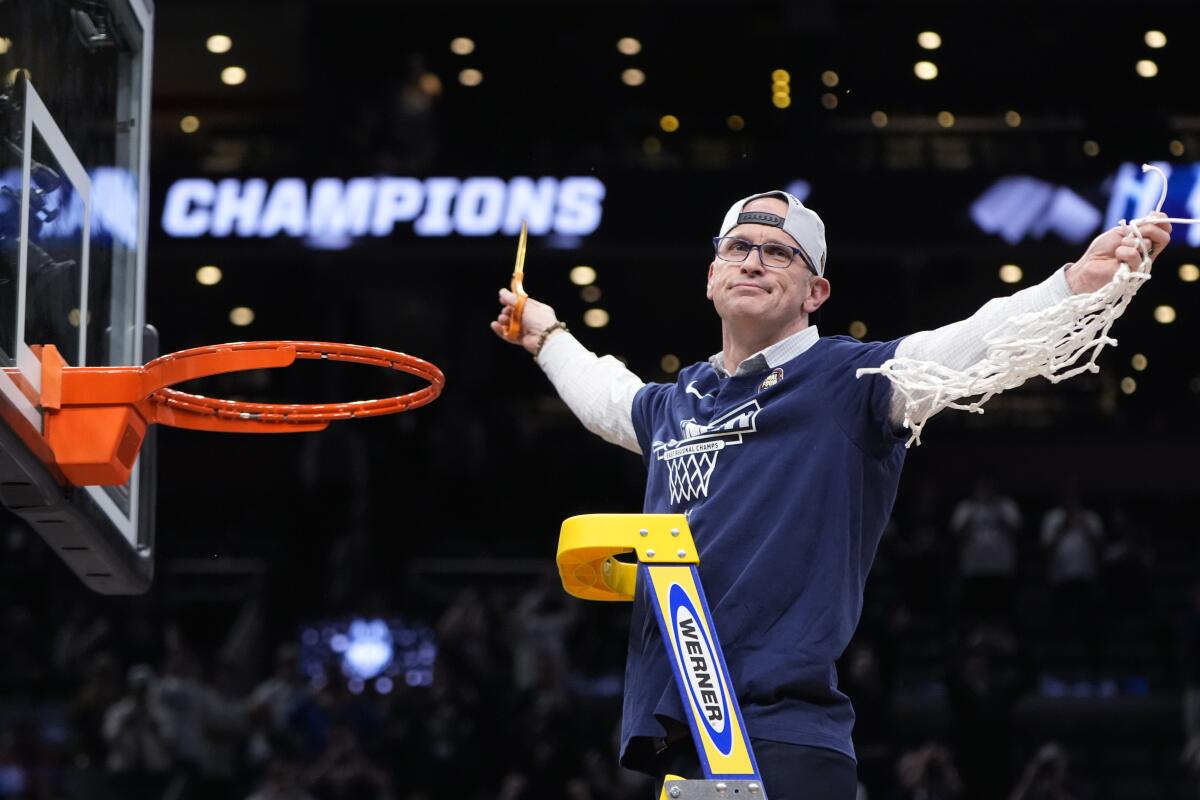 UConn coach Dan Hurley spreads his arms after cutting down the net celebrates after the Elite 8 tournament