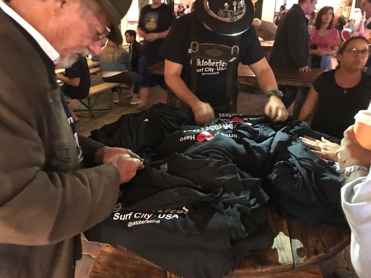 T-shirts for sale at Old World Village's Oktoberfest on Wednesday night read "Bernie is the Old World hero" in honor of owner Bernie Bischof, who was seriously injured in Saturday's explosions at the venue's German restaurant. A portion of the proceeds from shirt sales will go toward firefighters and workers injured in the blasts.