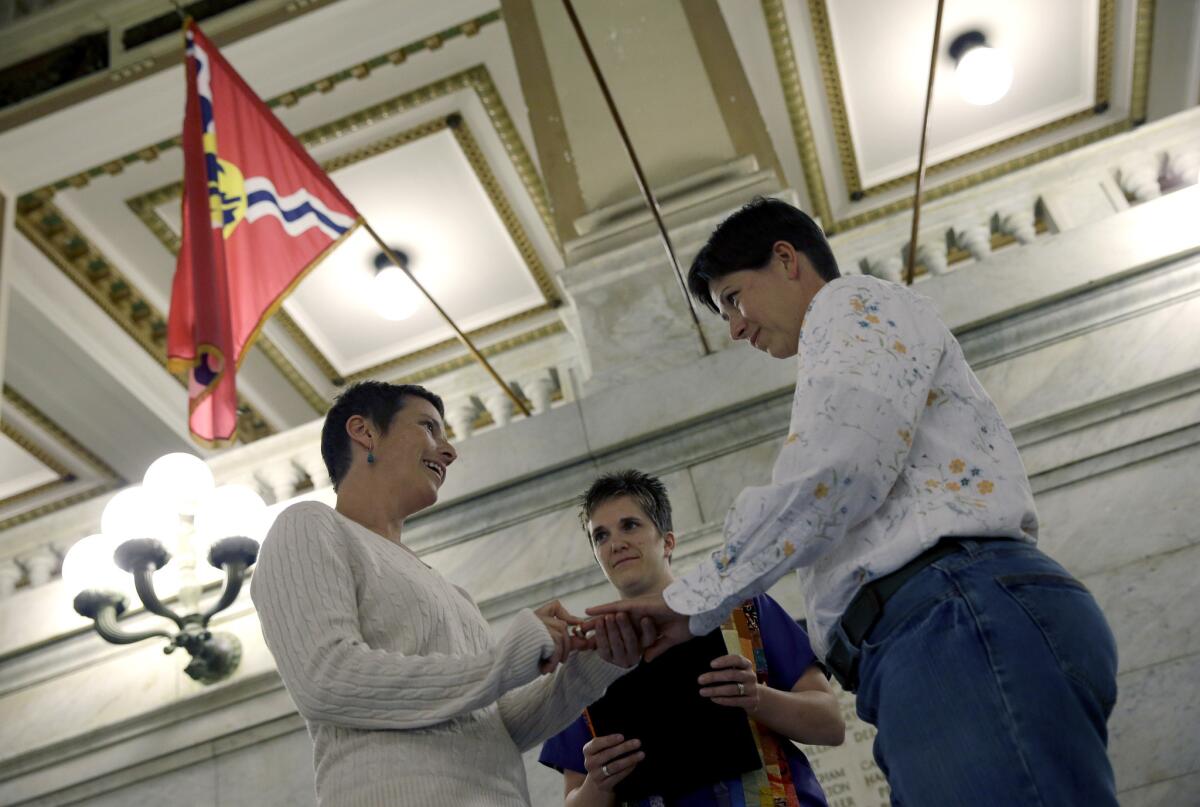 April Dawn Breeden, left, places a ring on the finger of her longtime partner Crystal Peairs, at their wedding in St. Louis on Wednesday, just after a state judge overturned Missouri's gay marriage ban.