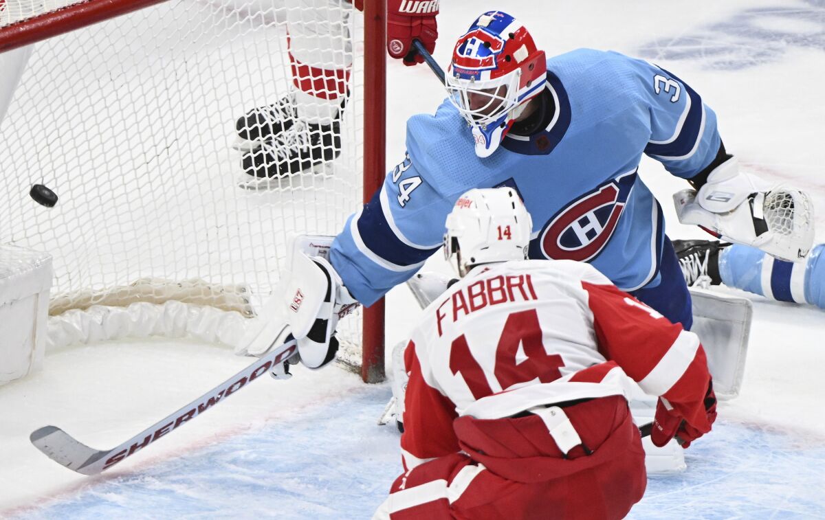 Detroit Red Wings' Robby Fabbri (14) scores against Montreal Canadiens goaltender Jake Allen (34) during overtime NHL hockey game action in Montreal, Thursday, Jan. 26, 2023. (Graham Hughes/The Canadian Press via AP)