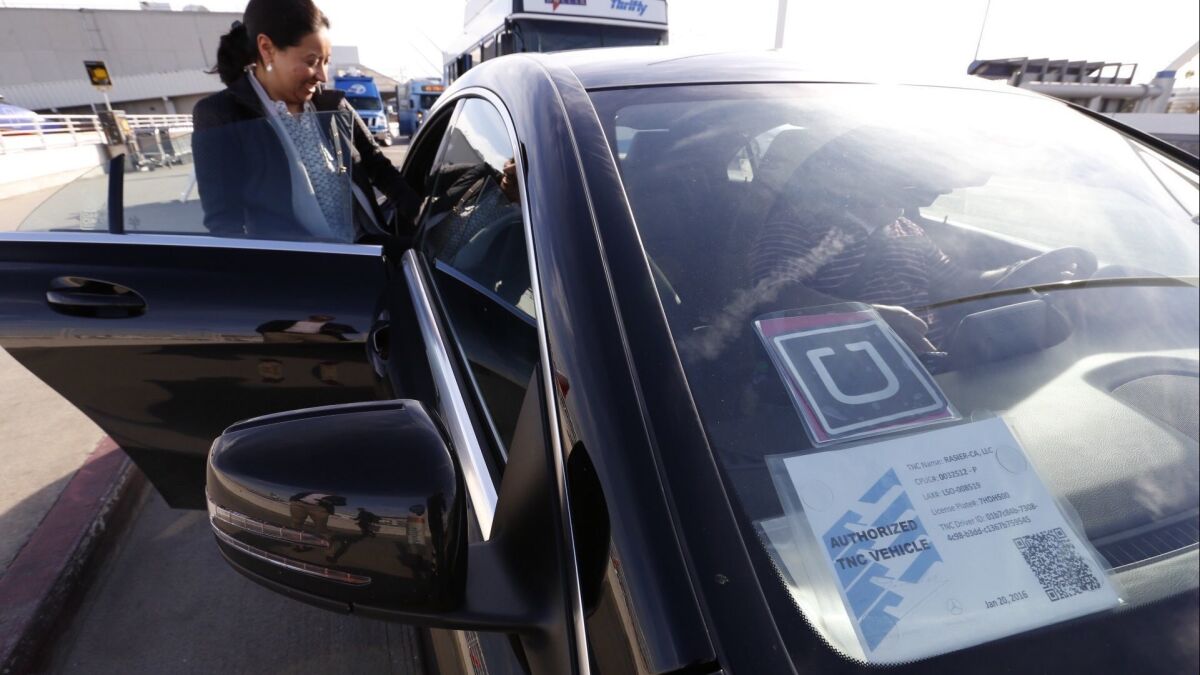 Ann Marie Bingo chats with Uber driver Mike Miller as UberX began making passenger pickups at Los Angeles International Airport in 2016, joining competing service Lyft.