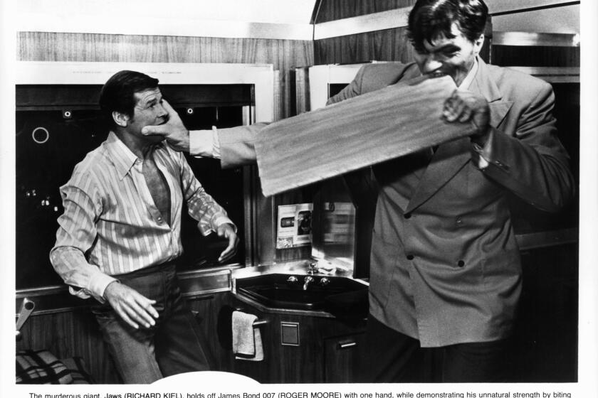 Roger Moore fights with Richard Kiel, as Jaws, who bites through a board in a scene from the 1977 film ''The Spy Who Loved Me." Kiel died Wednesday at the age of 74.