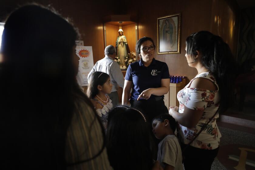 RIVERSIDE, CA -- AUGUST 18, 2019: Luz Gallegos, center, with the Training Occupational Development Educating Communities (TODEC) legal center, answers questions about the new "public charge" rule following church service at St. Francis de Sales church in Riverside. Undocumented parents are deciding to opt out of public benefits for their children because they are worried (likely wrongly) that it will hurt their own ability to gain legal status following the announcement of the rule. (Myung J. Chun / Los Angeles Times)