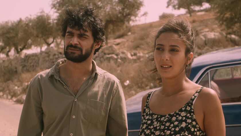 Firas Nassar and Mouna Hawa stand hear a car in "Between Heaven and Earth."