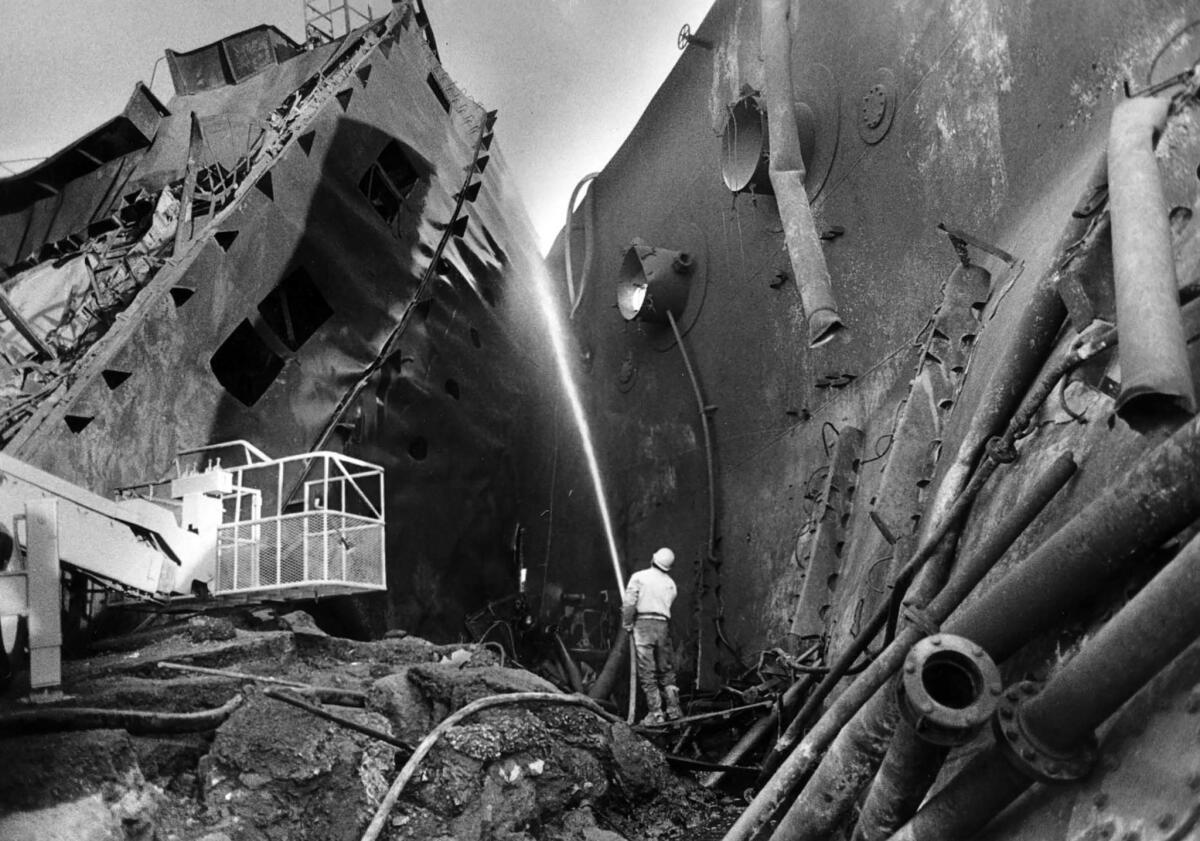 Dec. 27, 1976: A part of the bridge section of the Sansinena is sprayed with water. The main deck is to the right.