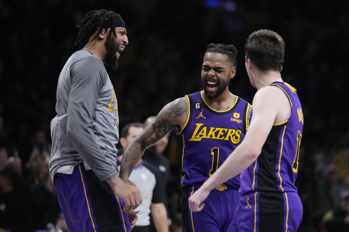 Lakers guard D'Angelo Russell, center, celebrates with Anthony Davis, left, and Austin Reaves.