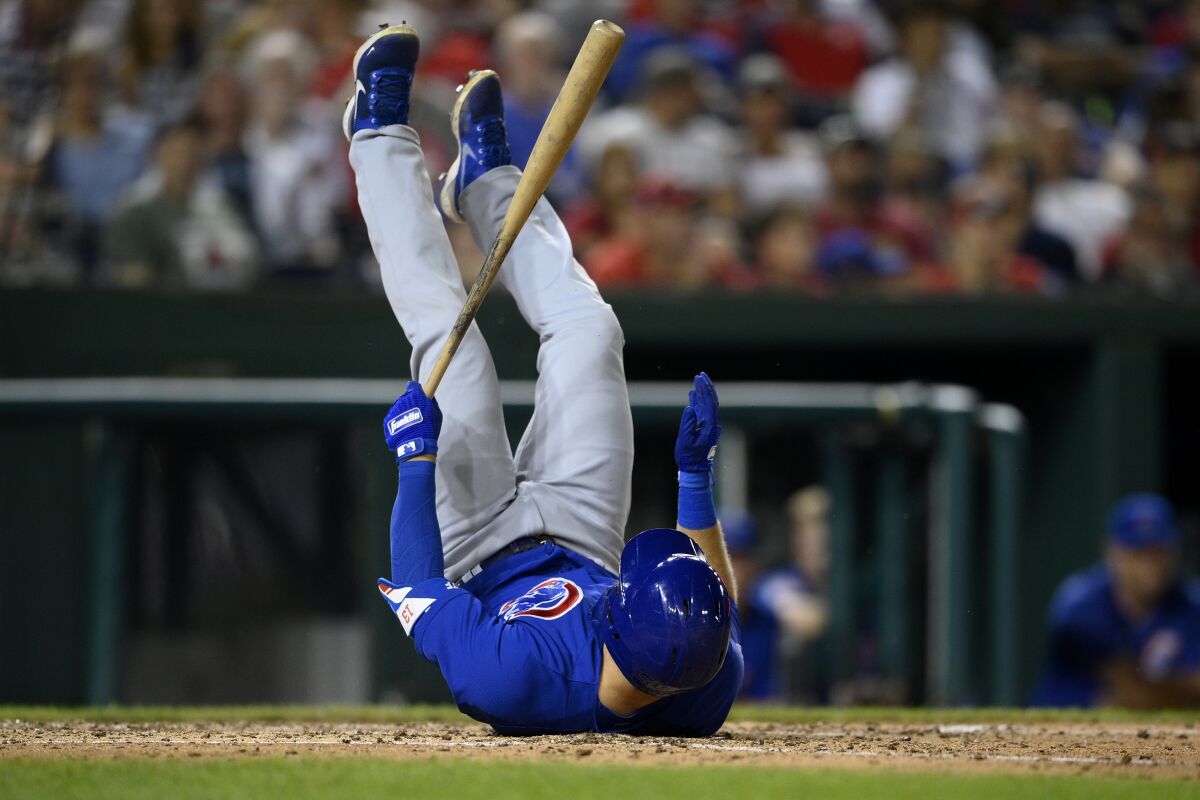 Chicago Cubs' David Bote rolls over after losing his balance while at-bat during the seventh inning of a baseball game against the Washington Nationals, Saturday, July 31, 2021, in Washington. (AP Photo/Nick Wass)