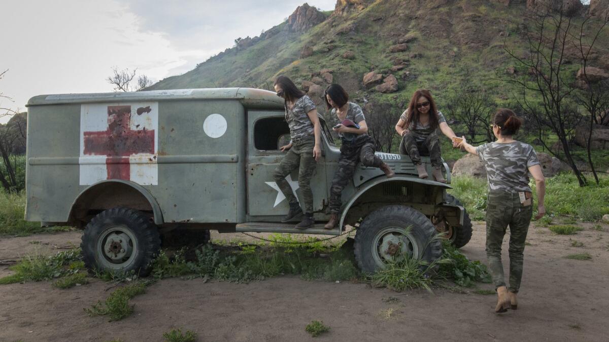Hikers Cici Koster, Richel Xu, Vivi Qin and Jenny Tu take turns posing for photos with a vehicle that survived the fire at the "MASH" filming site.