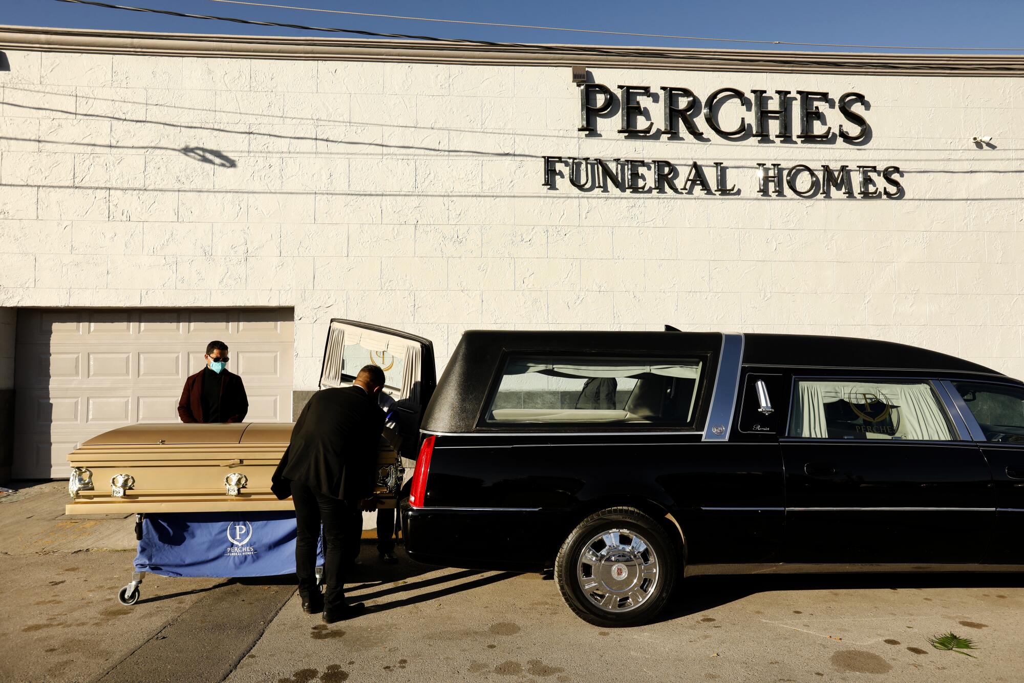 Dr. David González Velazco, left, beside his brother-in-law's casket outside Perches Funeral Home in Juarez, Mexico. 