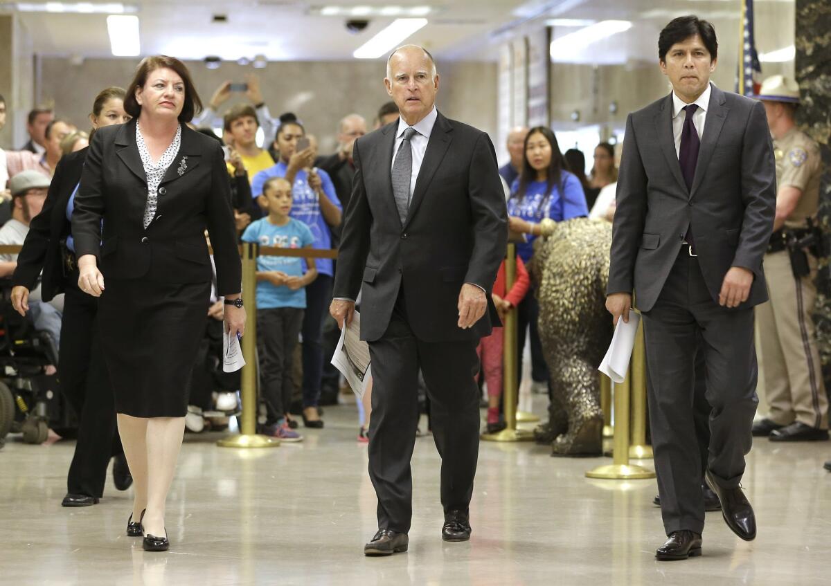 Gov. Jerry Brown, center, is flanked by Assembly Speaker Toni Atkins (D-San Diego) and Senate leader Kevin de Leon (D-Los Angeles) as they walk to a news conference last week in the Capitol to announce a budget agreement.