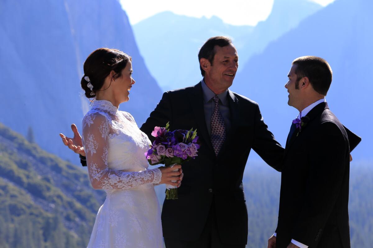 Moments after being married at Tunnel View, Cyrenea and Josh Piper, from College Station, Texas, talk with the Rev. Autrey Nassar, who conducted their ceremony. Nassar does 80 to 100 weddings a year in the park, often at the Yosemite Chapel (the oldest structure in the valley) or the Ahwahnee Hotel.