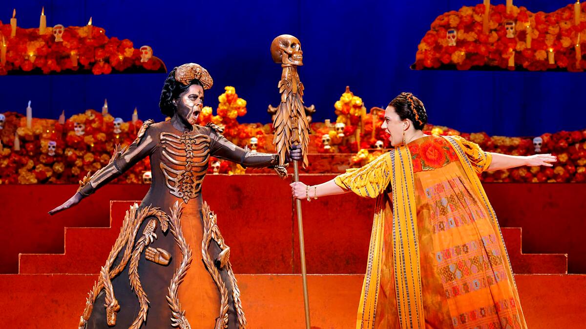 Performers costumed as a Day of the Dead calavera and Frida Kahlo perform a dramatic scene in an opera on stage
