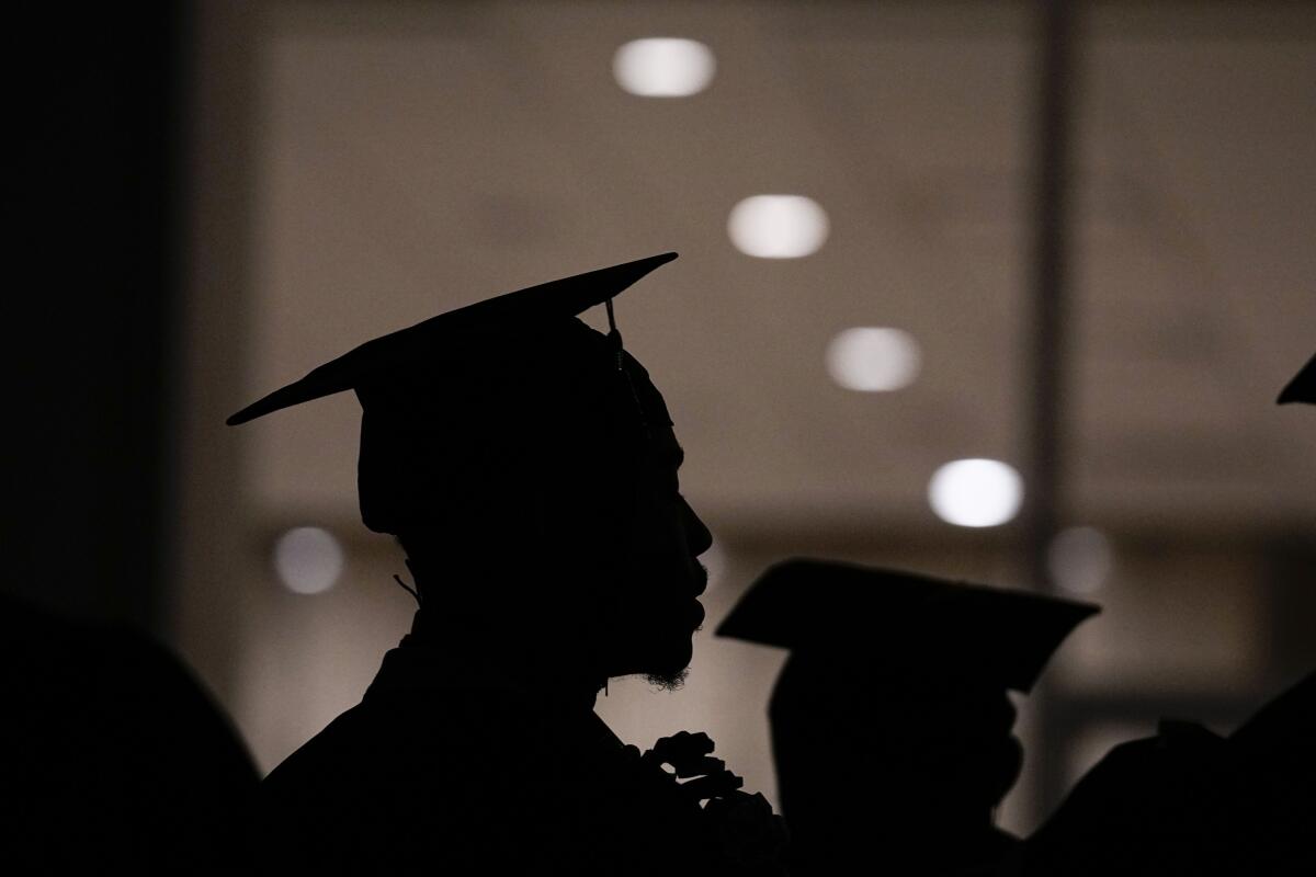 A profile shot of a Morehouse College student in silhouette with a mortarboard graduation cap