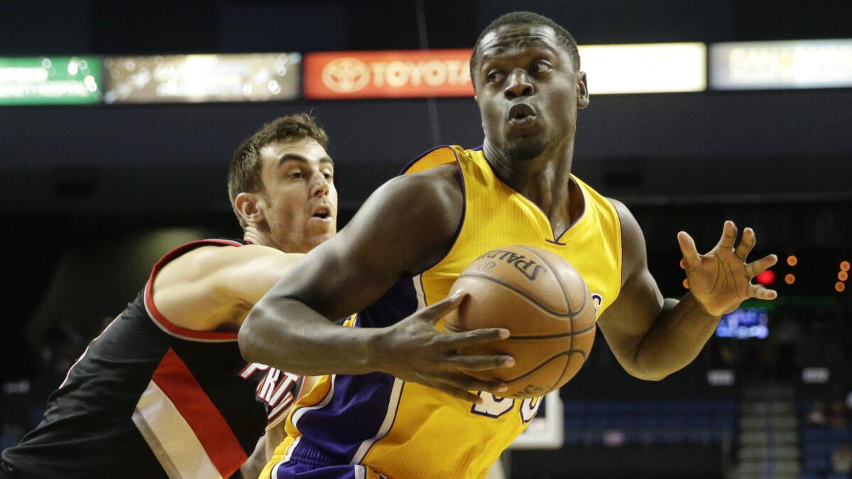 Lakers forward Julius Randle, right, is pressured by Portland Trail Blazers forward Victor Claver during the first half of the Lakers' 94-86 exhibition win.