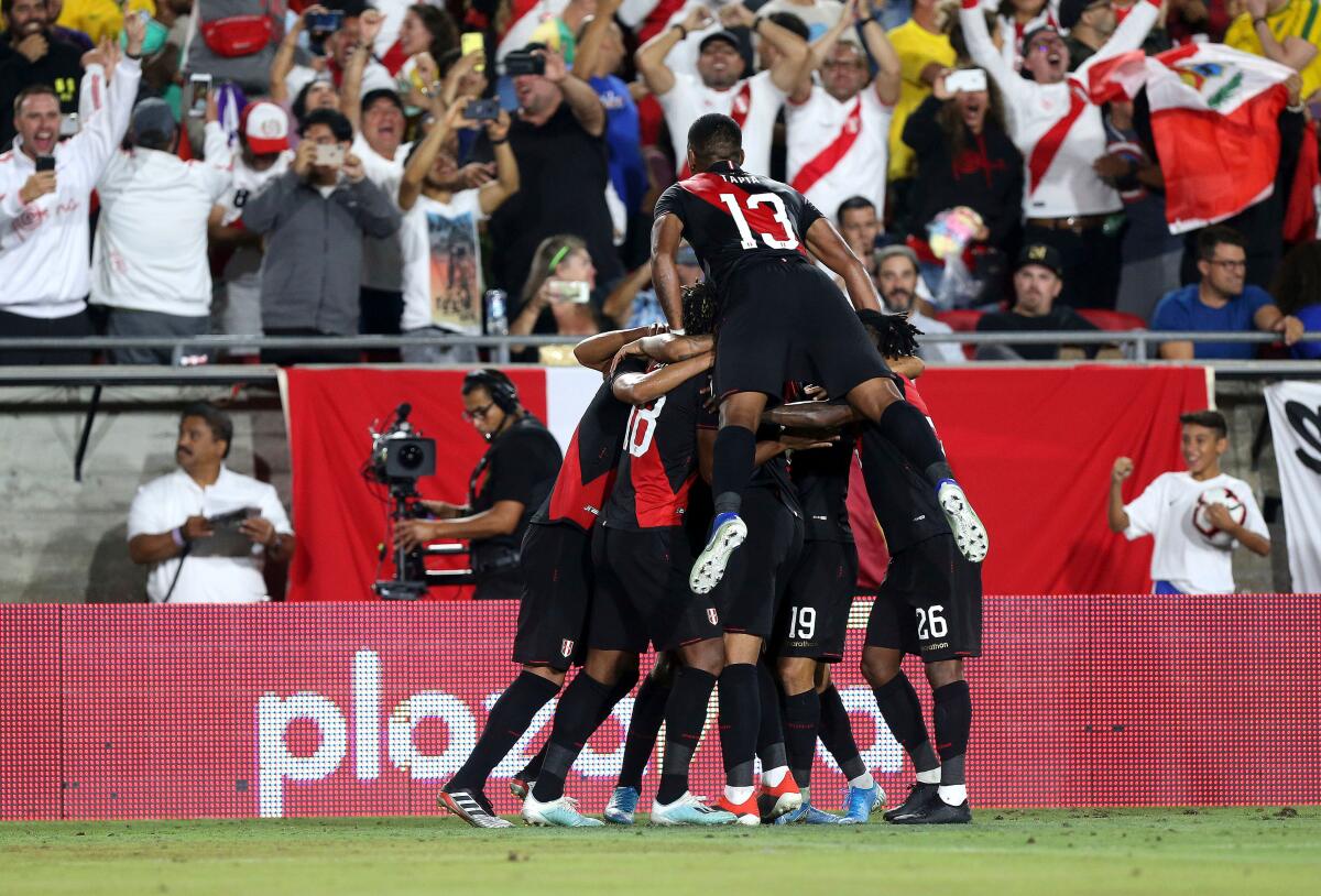 Peru celebrates after Luis Abram scores in the 85th minute of the second half during a friendly soccer match between Brazil and Peru at the Coliseum on Tuesday.