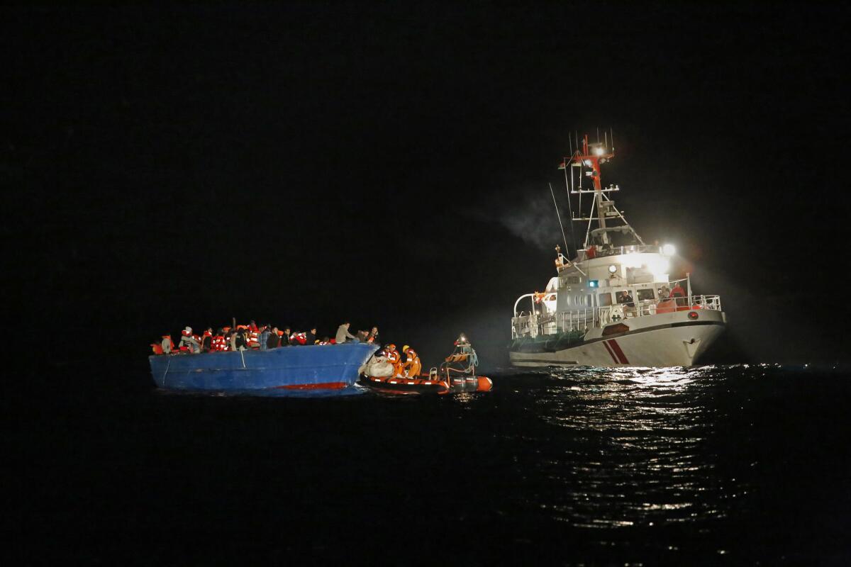 Three teams, including Save the Children, work to transport 412 migrants from a smuggler's boat to rescue ships off the coast of northern Libya. In the background is the rescue ship Minden.