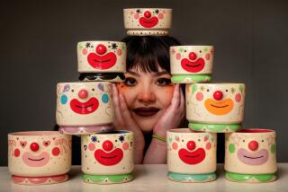 Soraya Yousefi is photographed with some of her ceramic clown-themed cups and bowls.