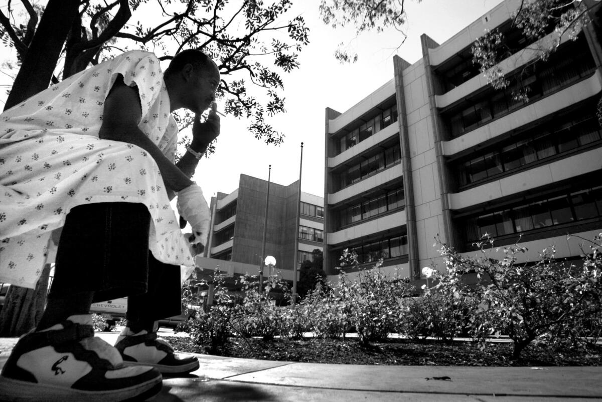 Albert Johnson, 46, who was admitted for a severe spider bite on his hand, sits outside the hospital for a smoke. "I brought it in a jar, I was sleeping and I felt something biting me."