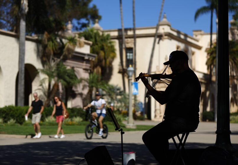 Josue Gascot of Imperial Beach sits in the shade on a warm afternoon in Balboa Park and plays "Have You Ever Seen The Rain?" by Creedence Clearwater Revival along with other songs on the violin on Monday, September 26, 2022.