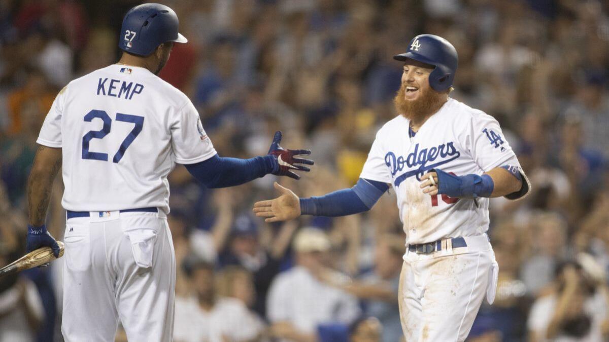 Dodgers' Matt Kemp, left, congratulates Justin Turner as he scores on a Manny Machado double in the seventh inning at Dodger Stadium on Wednesday.