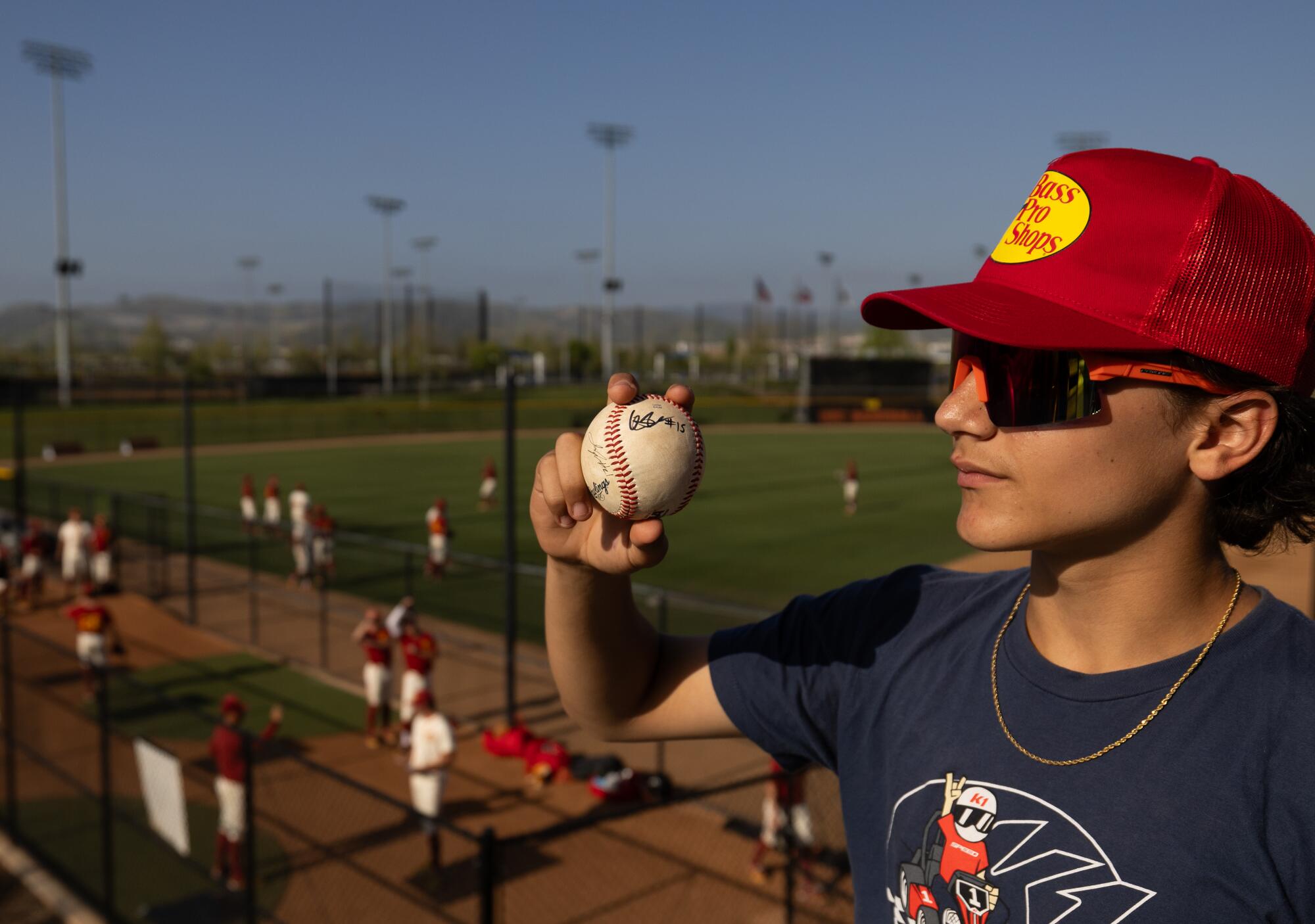 Josh Boatright, 14, of Irvine shows off his autograph on a baseball from USC infielder Ethan Hedges before the game on May 3.