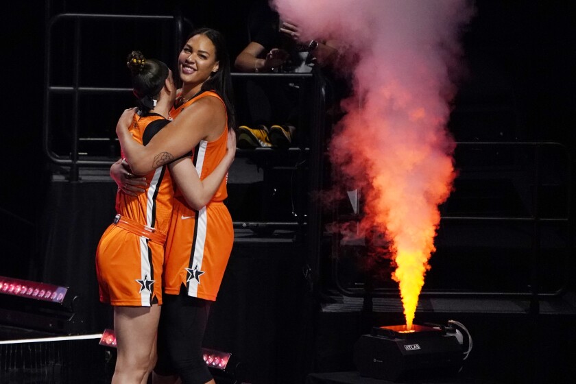 Team WNBA's Dearica Hamby, left, and Liz Cambage embrace before a WNBA All-Star basketball game against the United States, Wednesday, July 14, 2021, in Las Vegas. (AP Photo/John Locher)