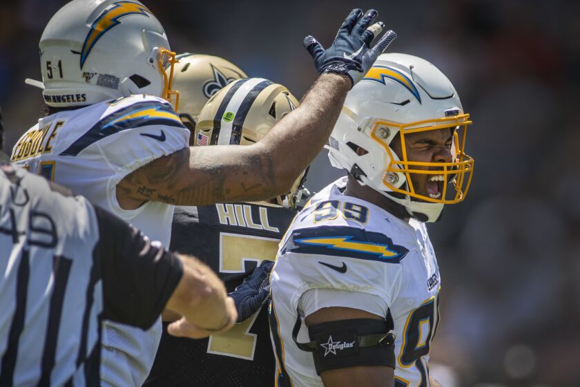 CARSON, CALIF. -- SUNDAY, AUGUST 18, 2019: Los Angeles Chargers linebacker Emeke Egbule, left, congratulates teammate defensive tackle Jerry Tillery, right, as he celebrates his first sack (New Orleans Saints quarterback Taysom Hill, #7, middle) of his pro career and first time suiting up as a Charger in the second quarter of a pre-season game at the StubHub Center in Carson, Calif., on Aug. 18, 2019. (Allen J. Schaben / Los Angeles Times)