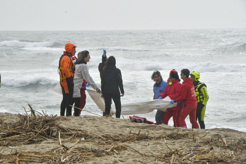 Rescuers recover a migrant's body at a beach near Cutro, southern Italy, on Sunday.