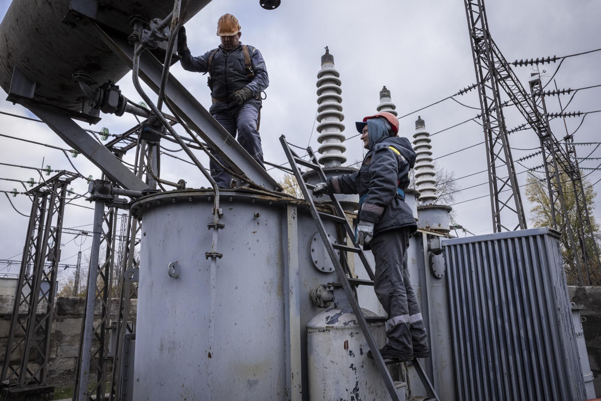 Workers repair a power station damaged by a Russian attack.