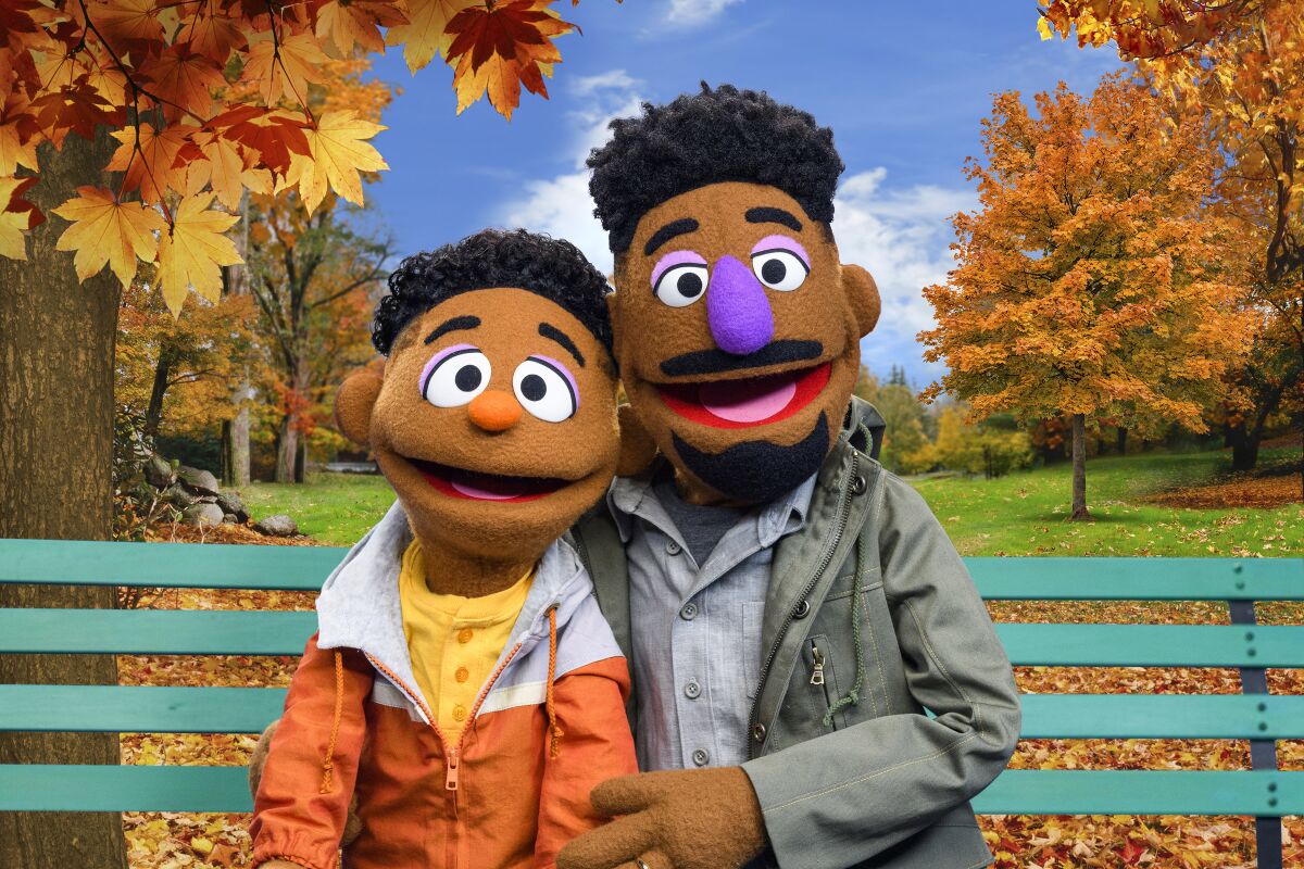 Two "Sesame Street" muppets sitting side-by-side on a park bench