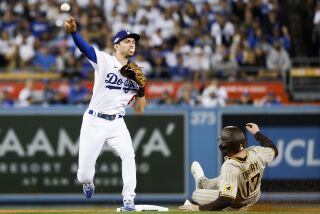 Los Angeles, CA - October 12: Los Angeles Dodgers shortstop Trea Turner, left, throws to first after forcing out San Diego Padres' Brandon Drury during the sixth inning in game two of the NLDS at Dodger Stadium on Wednesday, Oct. 12, 2022 in Los Angeles, CA.(K.C. Alfred / The San Diego Union-Tribune)