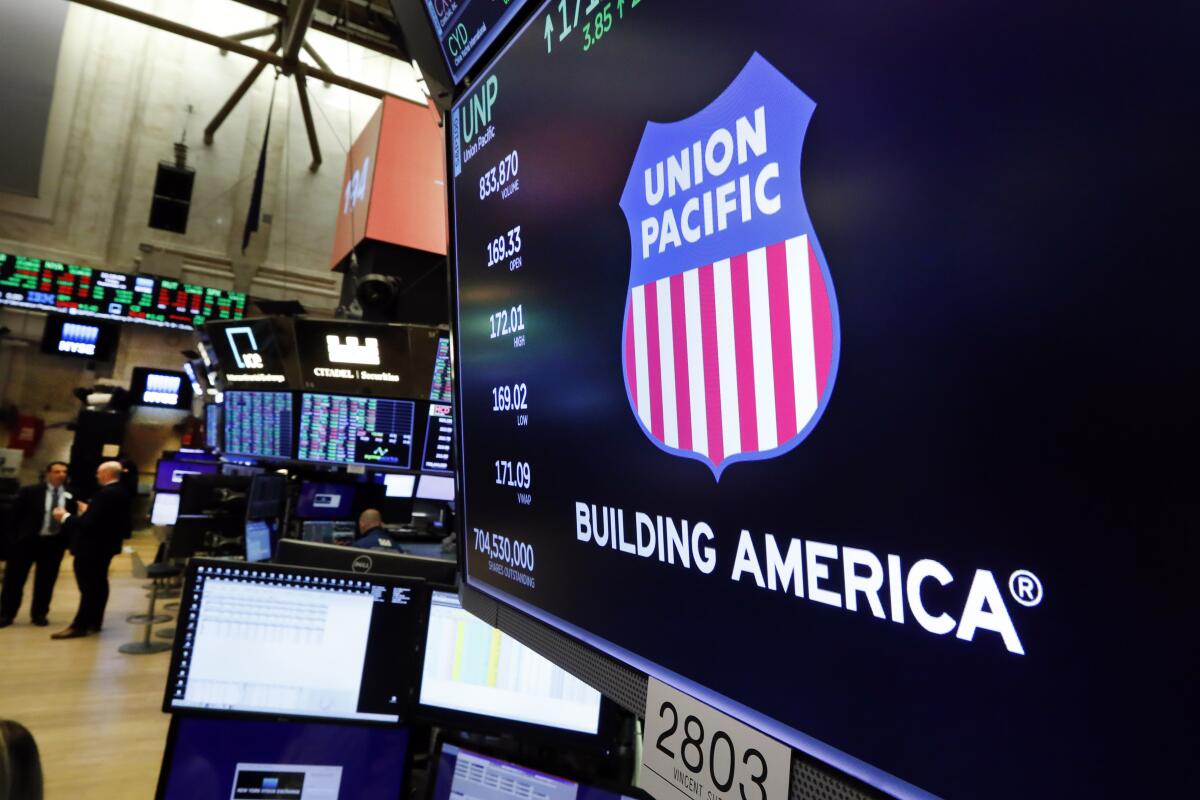 FILE - In this Sept. 13, 2019, file photo the logo for Union Pacific appears above a trading post on the floor of the New York Stock Exchange. Union Pacific hauled in 24% more profit in the fourth quarter even though supply chain problems and weak auto production continued to slow shipments because last year's results were weighed down by a one-time $278 million charge. The Omaha, Nebraska-based railroad said, Thursday, Jan. 20, 2022, it earned $1.71 billion, or $2.66 per share, during the quarter, and the results topped the Wall Street forecast for earnings of $2.60 per share. (AP Photo/Richard Drew, File)