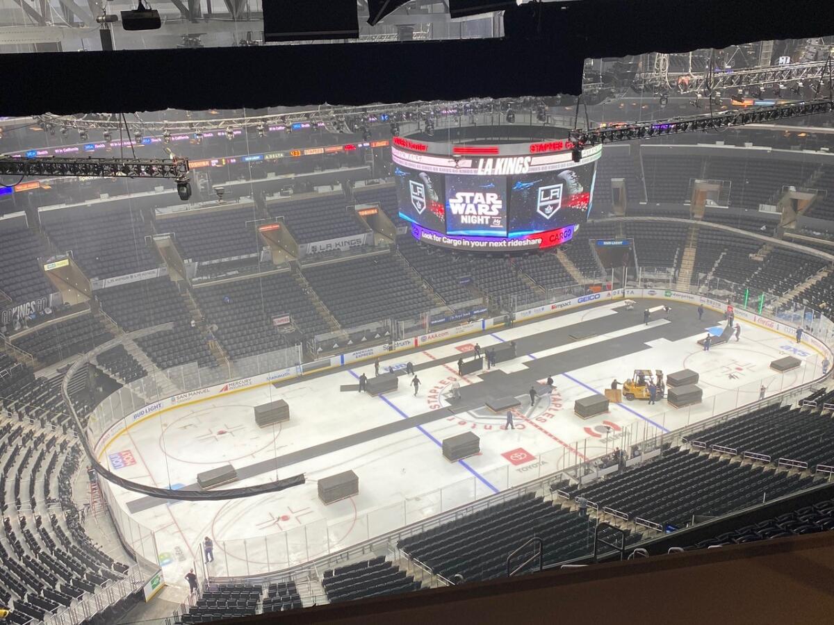 A crew works to change the basketball court to an ice hockey rink at Staples Center.