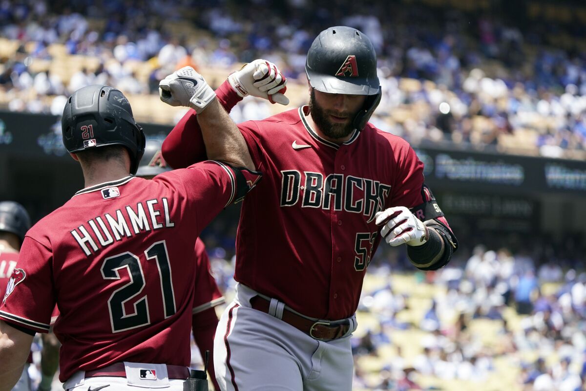 Arizona Diamondbacks' Christian Walker, right, celebrates his two-run home run Cooper Hummel (21) during the third inning of the first game of a baseball double-header against the Los Angeles Dodgers Tuesday, May 17, 2022, in Los Angeles. (AP Photo/Marcio Jose Sanchez)