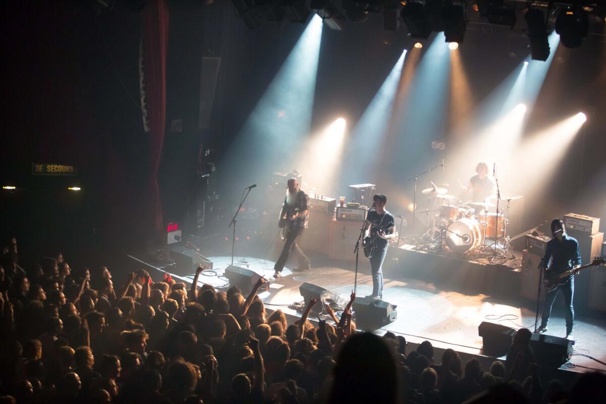 The Eagles of Death Metal, shown performing in Paris a few moments before three gunmen attacked concert-goers in November, will return to Paris for a Feb. 16 concert and will resume their postponed European tour.