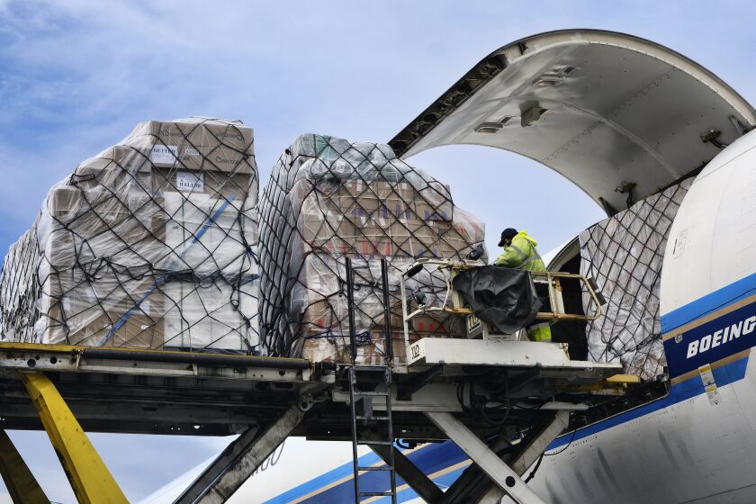 Ground crew at the Los Angeles International Airport unload pallets of supplies of medical personal protective equipment, PPE, from a China Southern Cargo plane upon arrival on Friday, April 10, 2020. (AP Photo/Richard Vogel)